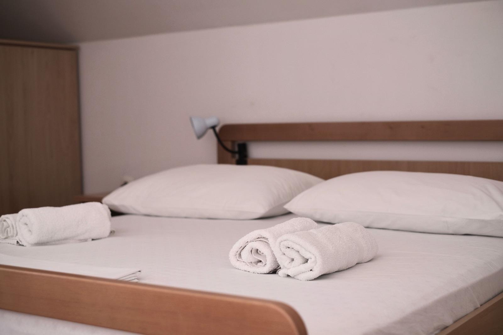 Bright bedroom with double bed in holiday apartment Vinišće, Croatia